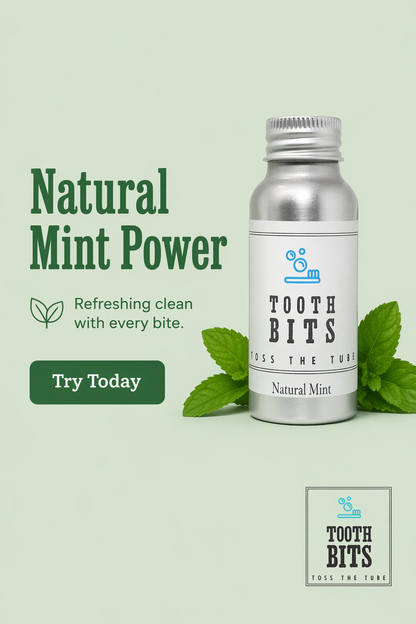 A silver bottle of Tooth Bits Natural Mint toothpaste displayed on a light sage green background with mint leaves and promotional text reading 'Natural Mint Power' and 'Try Today'.